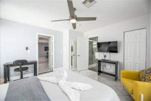 - une chambre blanche avec un lit et un ventilateur de plafond dans l'établissement The Pad at Coral Ridge 1, à Fort Lauderdale