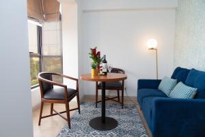- un salon avec une table et un canapé bleu dans l'établissement Hotel San Blas, à Lima