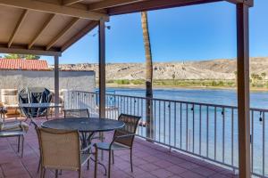 a patio with a table and chairs overlooking the water at Riverfront Bullhead City House with Balcony! in Bullhead City