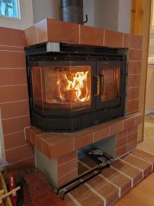 a brick fireplace with a fire in it at Kuća za odmor Bella in Sotin