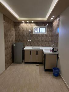 uma cozinha com um lavatório e um frigorífico em فندق ادوماتو ADOMATo HOTEl em Dawmat al Jandal