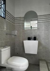 a bathroom with a white toilet and a mirror at 2-Bedroom Flat by PanAfri Homes in Accra