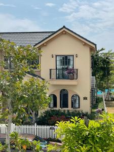 a house with a white fence in front of it at Le Gia Villa 1, sang trọng, bên hồ, hướng biển, 3PN, 3 phòng tắm, Novaworld Phan Thiết cho kỳ nghỉ gia đình in Phan Thiet