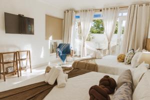 Un dormitorio con dos camas y una gran ventana. en Casa Blanca Conforto Neoclásico, Búzios/RJ, en Búzios 49 fotos más