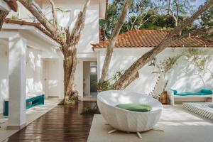 bañera en el medio de una habitación con árboles en Casa Blanca Conforto Neoclásico, Búzios/RJ, en Búzios