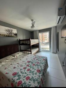 1 dormitorio con 1 cama con colcha de flores en Apto Prox Proximo Dunas, Vista Mar, en Cabo Frío