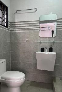a bathroom with a white toilet and a sink at 2-Bedroom Flat by PanAfri Homes in Accra