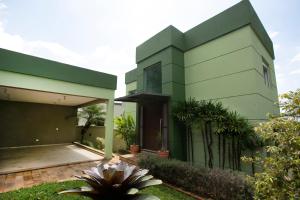 a green house with a garden in front of it at Natureza na cidade in Atibaia