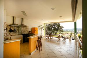 a kitchen with a counter and a balcony with a table at Natureza na cidade in Atibaia