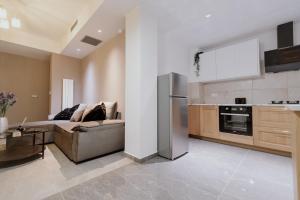 een woonkamer met een bank en een keuken bij Elpidas Apartment in Athene