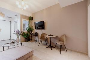 sala de estar con 2 sillas, mesa y TV en Elpidas Apartment, en Atenas