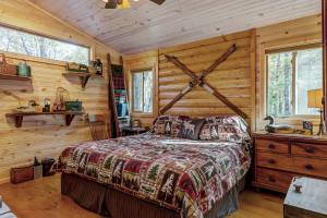 ein Schlafzimmer mit einem Bett mit einer Holzwand in der Unterkunft Secluded & Charming Lake Access Woodland Chalet by Sarah Bernard in Innsbrook