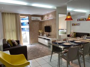 sala de estar con mesa de comedor y sala de estar con sofá en Beira Mar Apartmento 306 en Maceió