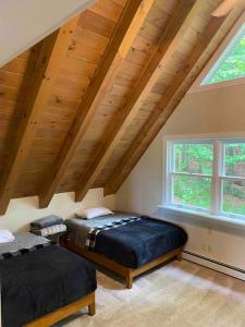 a attic bedroom with two beds and a window at Northern Vermont custom home near Stowe & Smuggs in Johnson