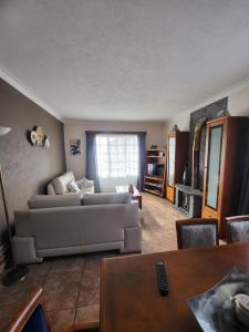 - un salon avec un canapé et une table dans l'établissement Casa da Palmeira, à Velas