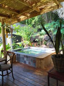 una piscina en una terraza de madera con aitating en La petite case jaune , jaccuzi pierre à 3 min à pied du bassin Manapany, vue mer, en Saint-Joseph