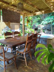 una mesa de madera y sillas en una terraza en La petite case jaune , jaccuzi pierre à 3 min à pied du bassin Manapany, vue mer, en Saint-Joseph