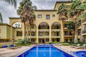 un hotel con piscina e palme di Elegant two bedroom condo tranquil with pool a San Miguel de Allende
