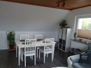 a dining room with a white table and chairs at Seeblick- Noer in Noer