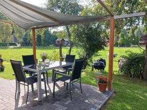 a patio with a table and chairs and a grill at Seeblick- Noer in Noer