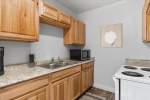 a kitchen with wooden cabinets and a sink and a microwave at 216: Lovely 1 bedroom close to amenities! in Billings