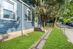 a blue house with a sidewalk next to a yard at 216: Lovely 1 bedroom close to amenities! in Billings