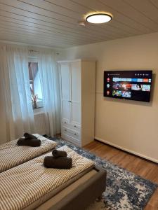 a bedroom with two beds and a flat screen tv at Gemütliche Wohnung nähe Alsfeld - Parkplatz in Alsfeld