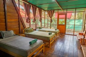 2 letti in una camera con finestre di Aroldo Amazon Lodge a Puerto Maldonado