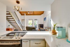 a kitchen with white walls and a staircase at Top-Floor Kailua Bay Resort Condo with Ocean Views! in Kailua-Kona