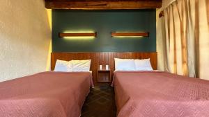 two beds sitting next to each other in a room at Hotel Muk´ul Na in San Cristóbal de Las Casas +7 photos