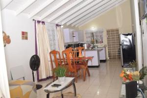 una cucina e una sala da pranzo con tavolo e sedie di Rhyne Park Inn a Montego Bay