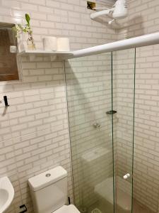 a bathroom with a toilet and a glass shower at Casa Pitanga - Abraão - Ilha Grande in Abraão