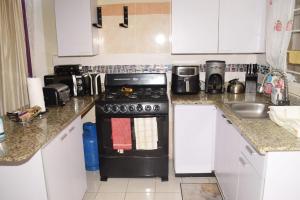 a kitchen with a black stove and a sink at Rhyne Park Inn in Montego Bay