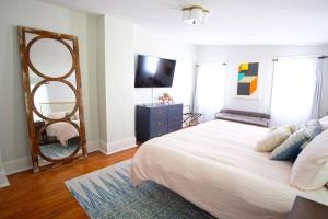 a bedroom with a large bed and a mirror at Carriage House on Chatham Sq in Savannah