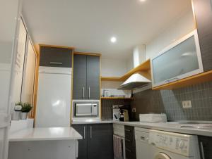 una cucina con frigorifero bianco e forno a microonde di La Alameda Jardines del Prado -Amplio y con ascensor- a Talavera de la Reina