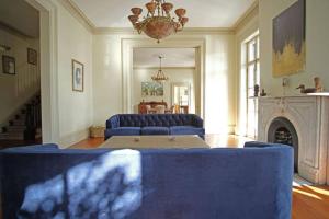 a living room with blue couches and a fireplace at Hamilton House - 5BR Historic Home with Courtyard and Garage in Savannah