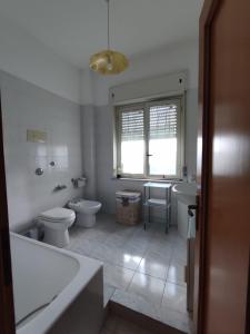 a bathroom with two toilets and a tub and a sink at Casa con Giardino in Milazzo