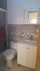 a bathroom with a toilet and a sink and a mirror at Semi Amoblado Manta Mall del Pacifico; Playa Murciélago in Manta