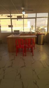 a kitchen with two red chairs and a table with a sink at Semi Amoblado Manta Mall del Pacifico; Playa Murciélago in Manta