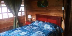 een slaapkamer met een bed in een kamer met houten wanden bij Cabanas Armonia in Cotundo