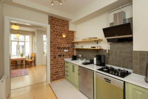 a kitchen with green cabinets and a brick wall at Lemon Apartments in Istanbul