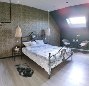 a bedroom with a large bed and two chairs at La folie 20 Spa in Hon-Hergies