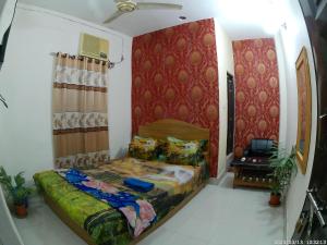 1 dormitorio con cama y pared roja en Hotel Rongdhanu Residential, en Dhaka