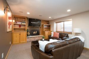 a living room with a leather couch and a television at Beard Avenue Bungalow! in Minneapolis