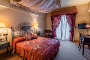 a bedroom with a bed and a desk and a window at Hotel Alhama in Cintruénigo