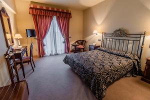 um quarto com uma cama, uma secretária e uma janela em Hotel Alhama em Cintruénigo