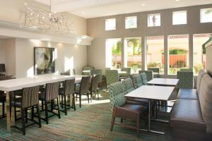 un comedor con mesas, sillas y ventanas en Residence Inn Phoenix Mesa, en Mesa
