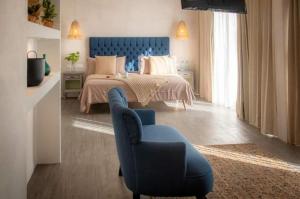 a bedroom with a bed and a blue chair at Hotel The Palm in Playa del Carmen