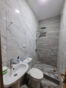 a white bathroom with a toilet and a sink at Green Garden - Crimea in Tbilisi City
