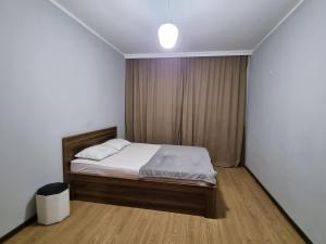 a small bedroom with a bed with white sheets at Green Garden - Crimea in Tbilisi City
